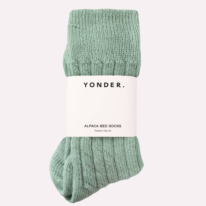 Green alpaca bed socks with 'Yonder' label on a white background