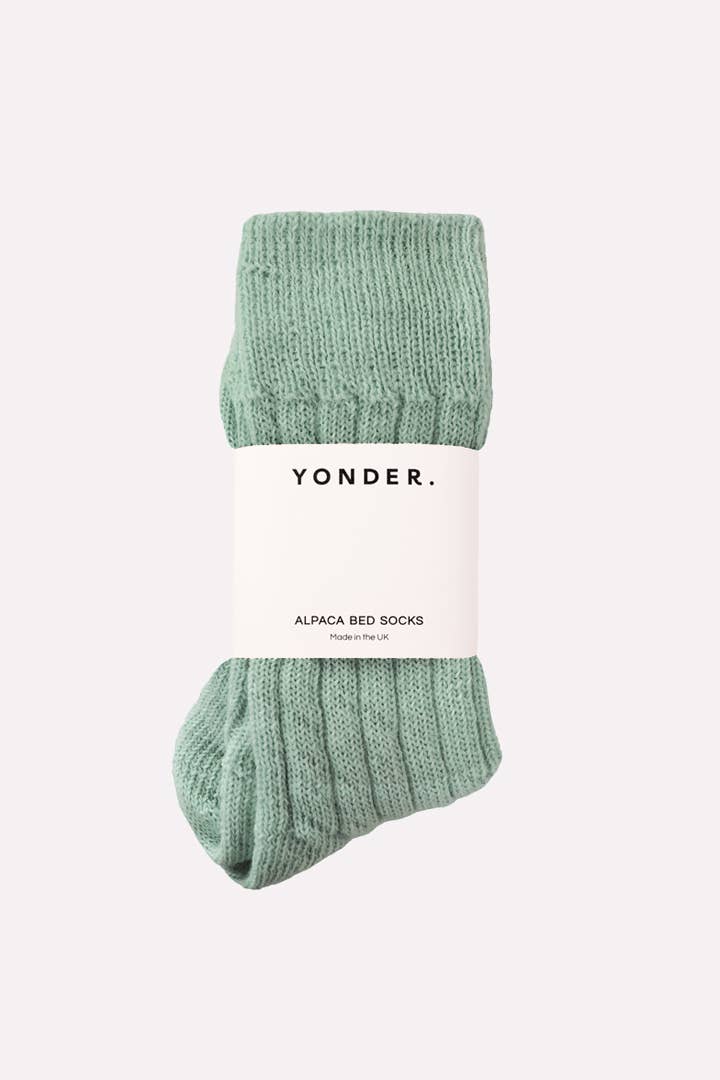Green alpaca bed socks with 'Yonder' label on a white background