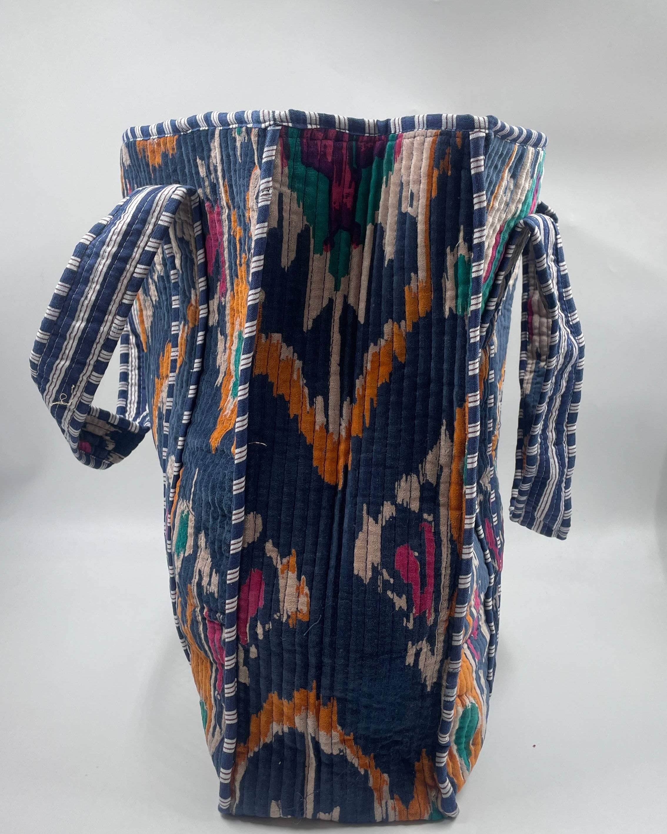 Colorful woven bag with geometric pattern on a white background