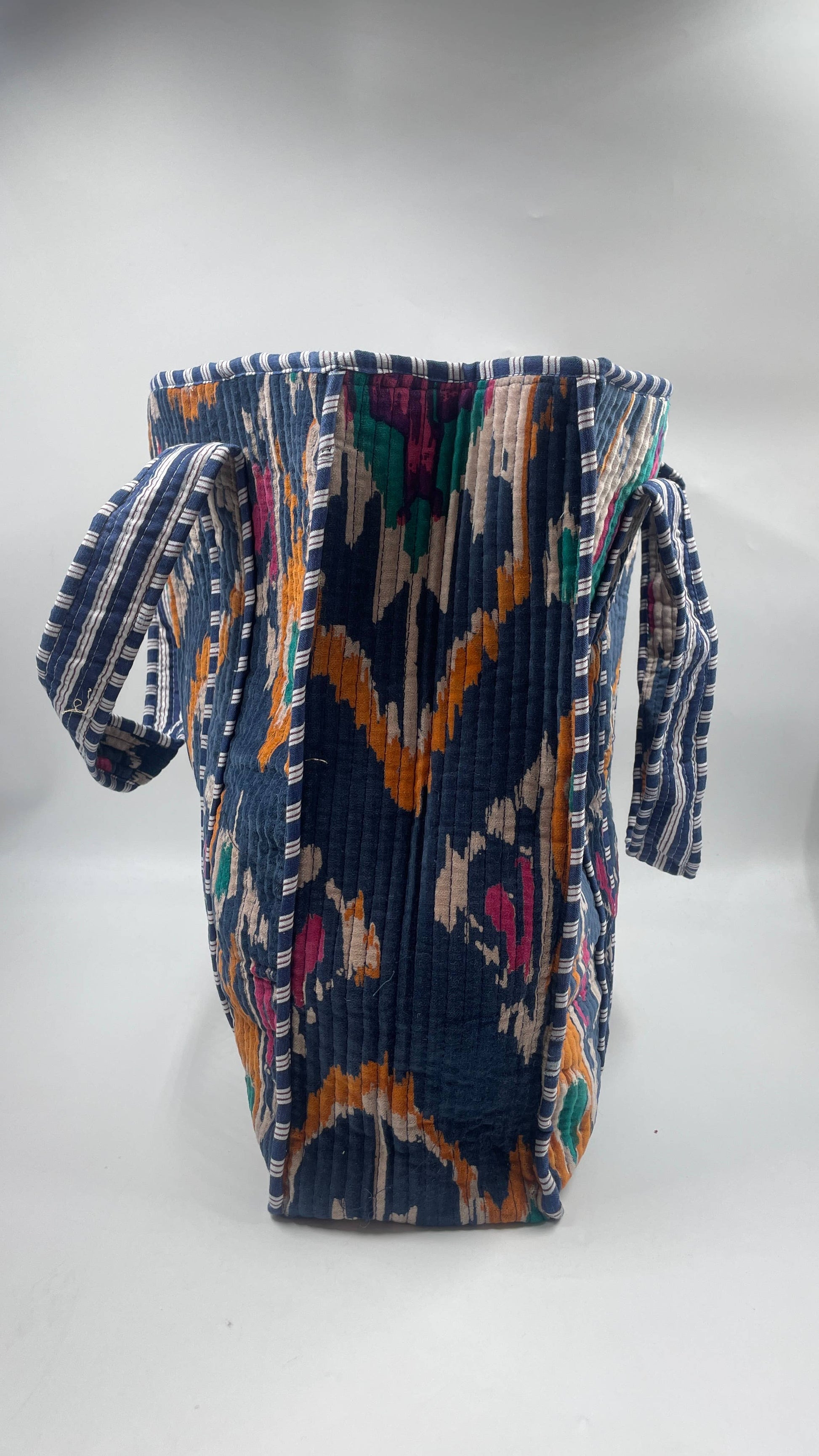 Colorful woven bag with geometric pattern on a white background
