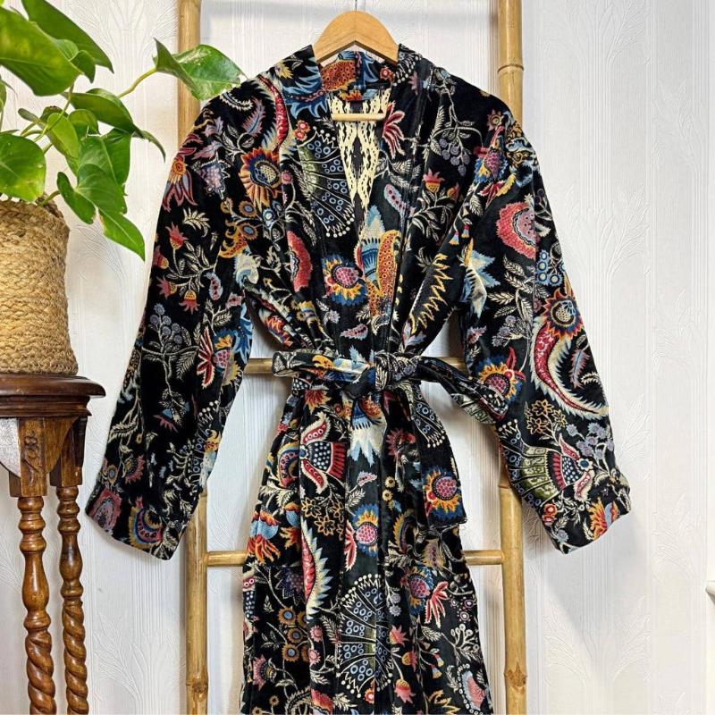 Colorful patterned robe hanging on a wooden rack with a plant in the background
