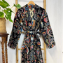 Colorful patterned robe hanging on a wooden rack with a plant in the background
