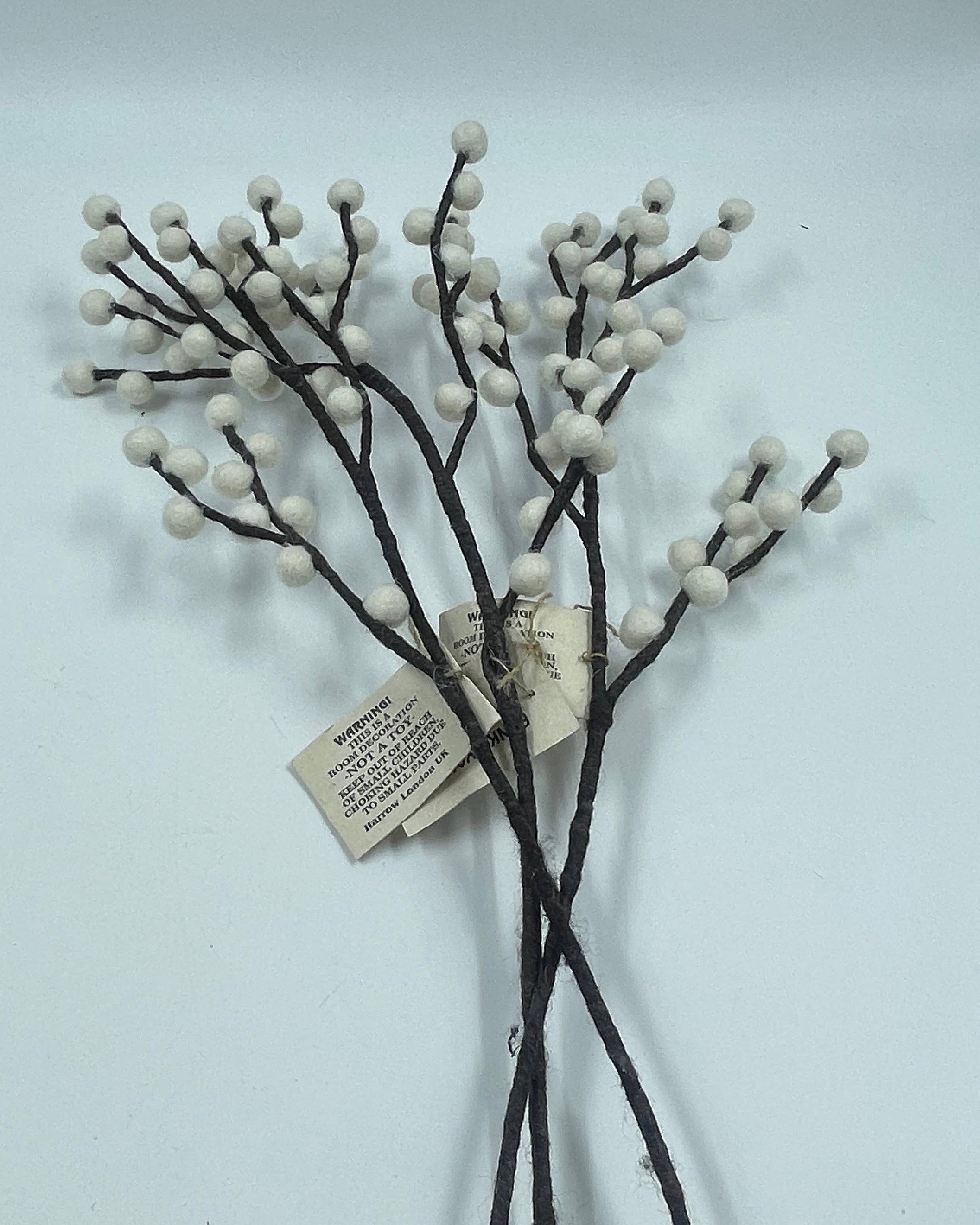 Decorative branches with white berries on a light gray background