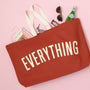 Red tote bag with 'EVERYTHING' text on a pink background