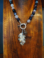 Necklace with leaf pendant on a wooden surface