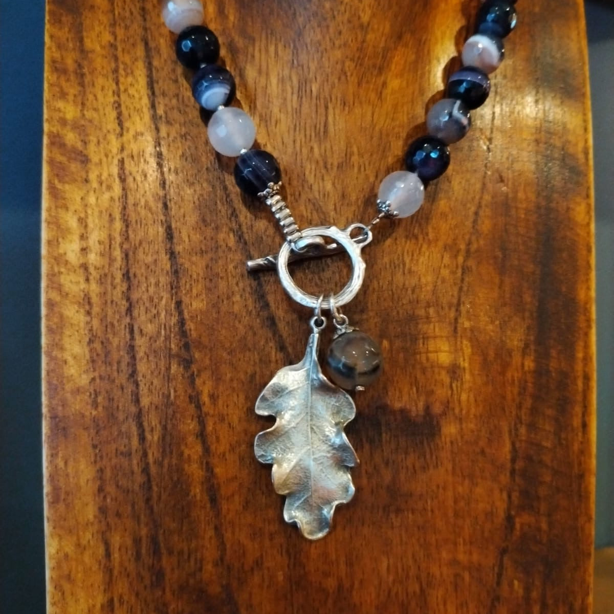 Necklace with leaf pendant on a wooden surface