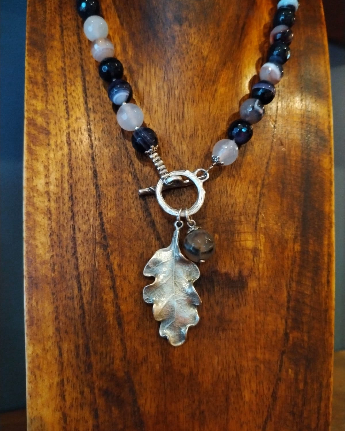 Necklace with leaf pendant on a wooden surface