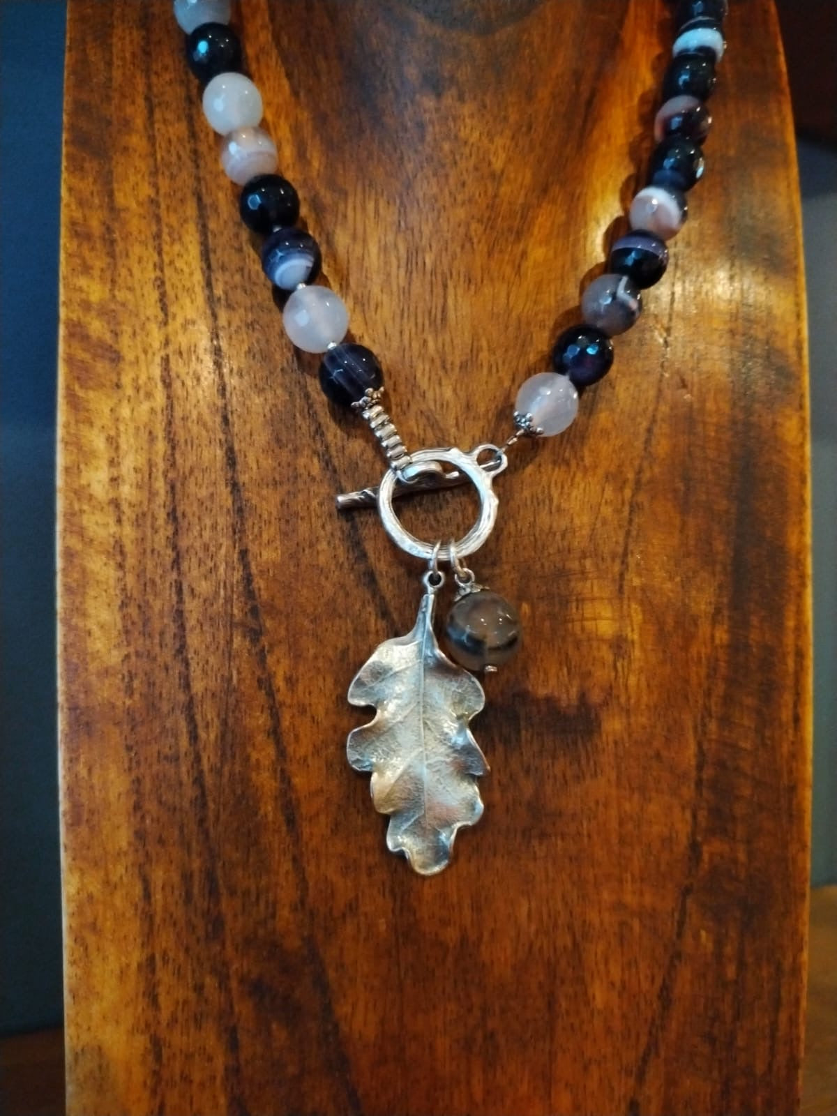 Necklace with leaf pendant on a wooden surface