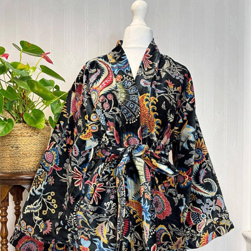 Colorful patterned scarf draped over a mannequin with a plant in the background