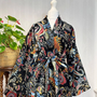 Colorful patterned scarf draped over a mannequin with a plant in the background
