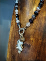 Necklace with leaf charm on a wooden surface