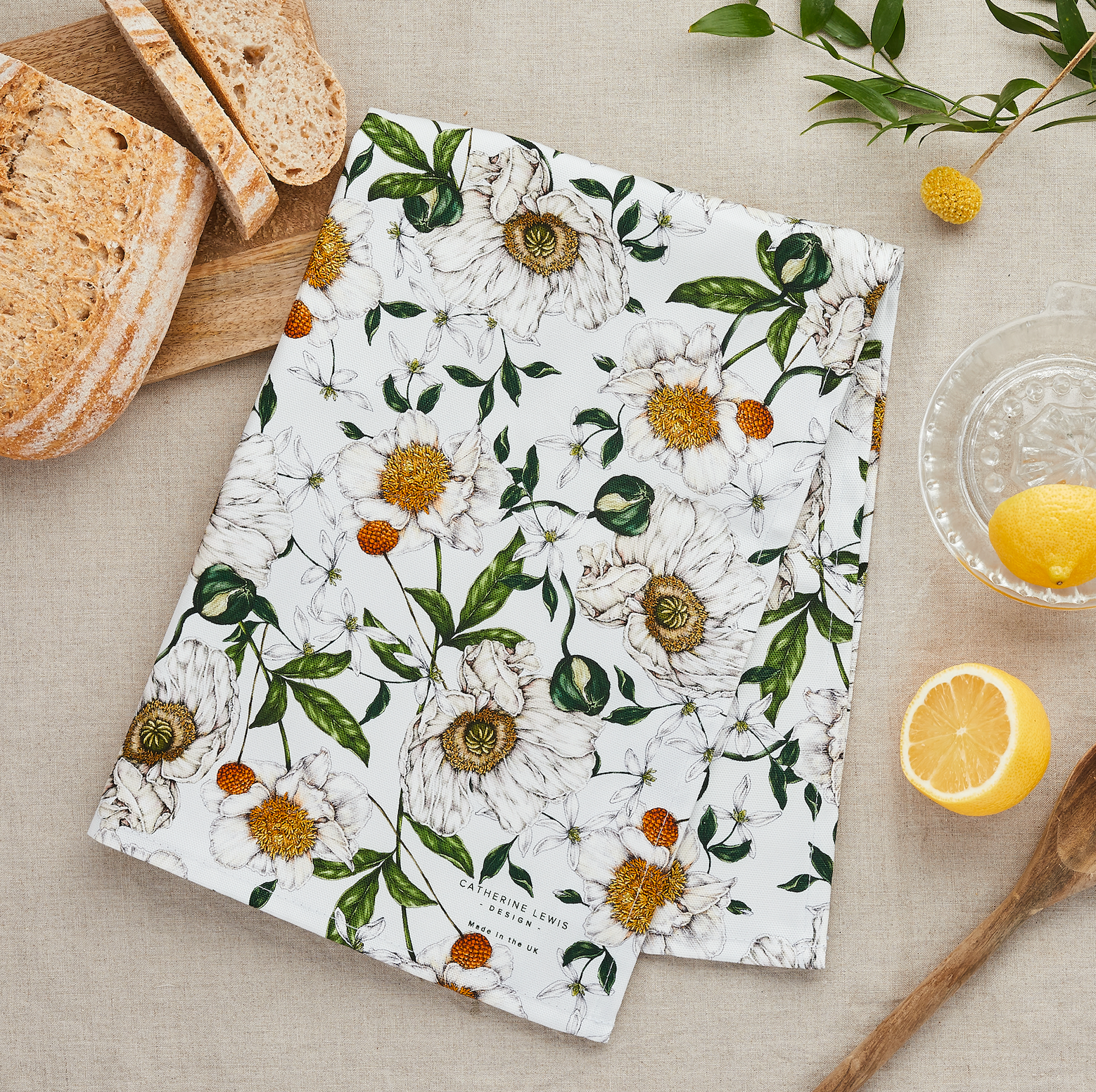 Floral-patterned towel on a table with bread and lemons