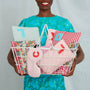 Person holding a basket of decorative pillows with colorful patterns and numbers.