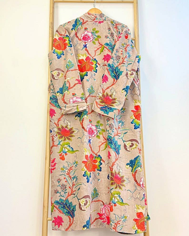 Colorful floral-patterned robe hanging on a wooden rack against a white background