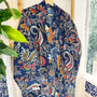 Colorful floral-patterned garment hanging on a rack with a window in the background