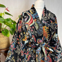 Colorful patterned scarf on a mannequin with a plant in the background