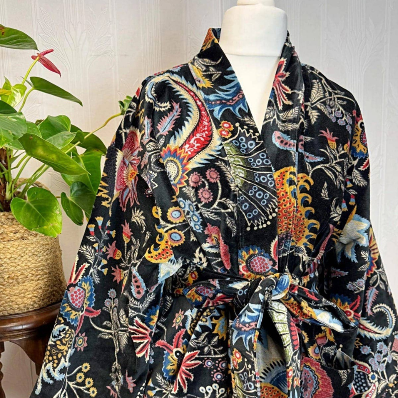 Colorful patterned scarf on a mannequin with a plant in the background