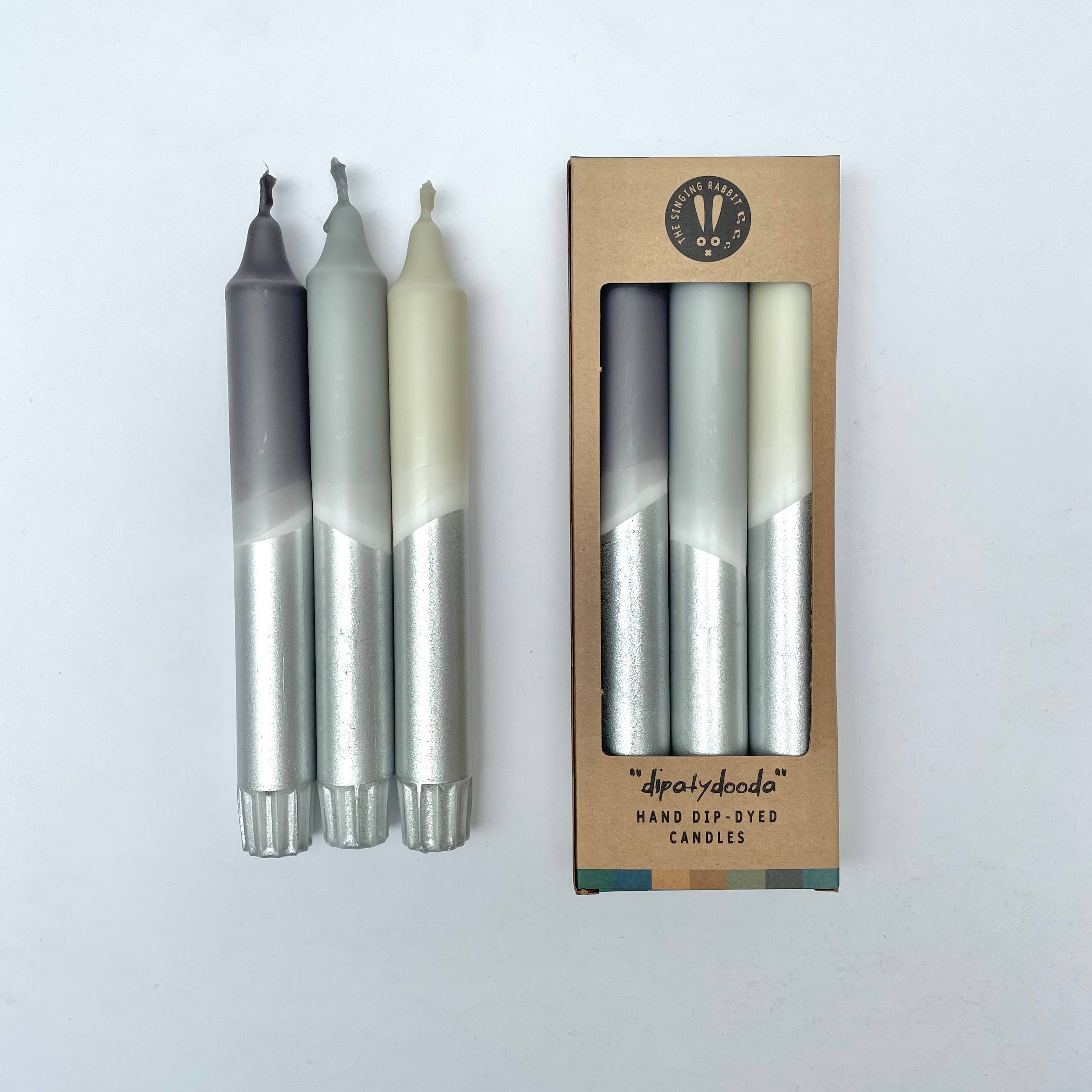 Set of hand-dyed candles with a cardboard packaging box on a white background