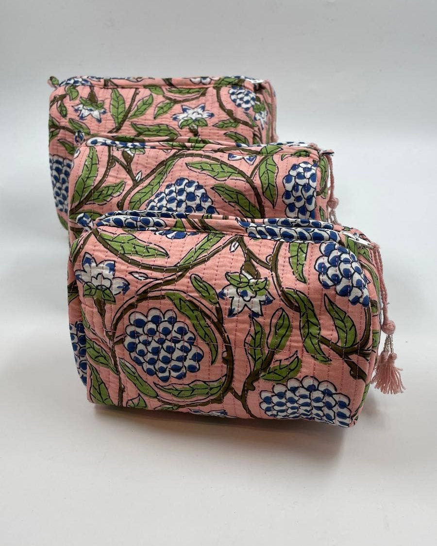 Two pink floral-patterned bags stacked on a white background