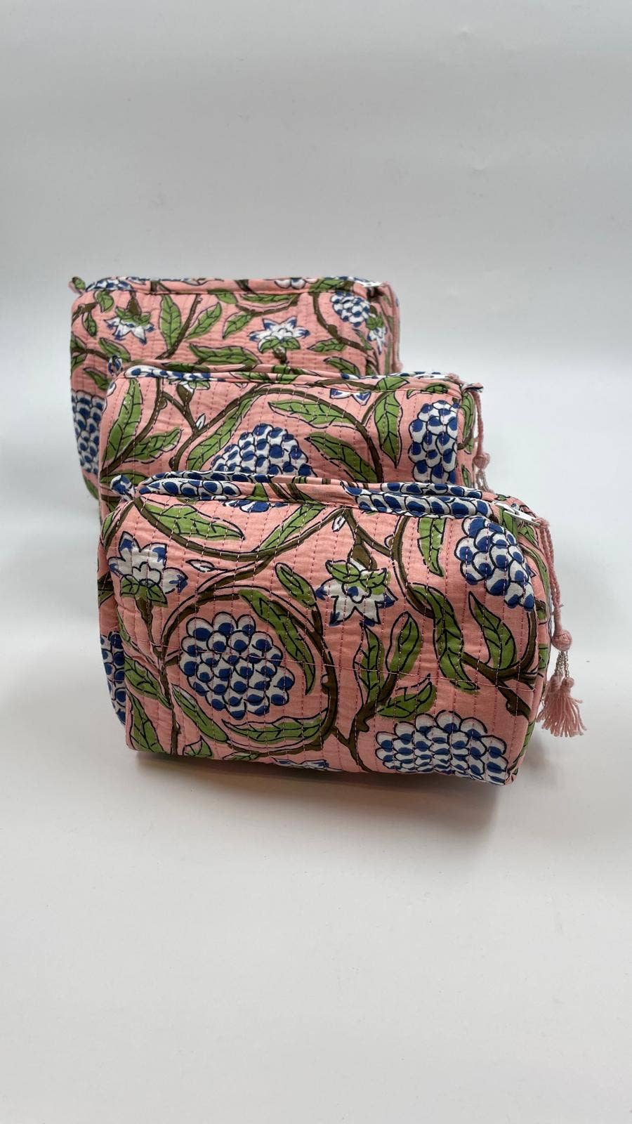 Two pink floral-patterned bags stacked on a white background