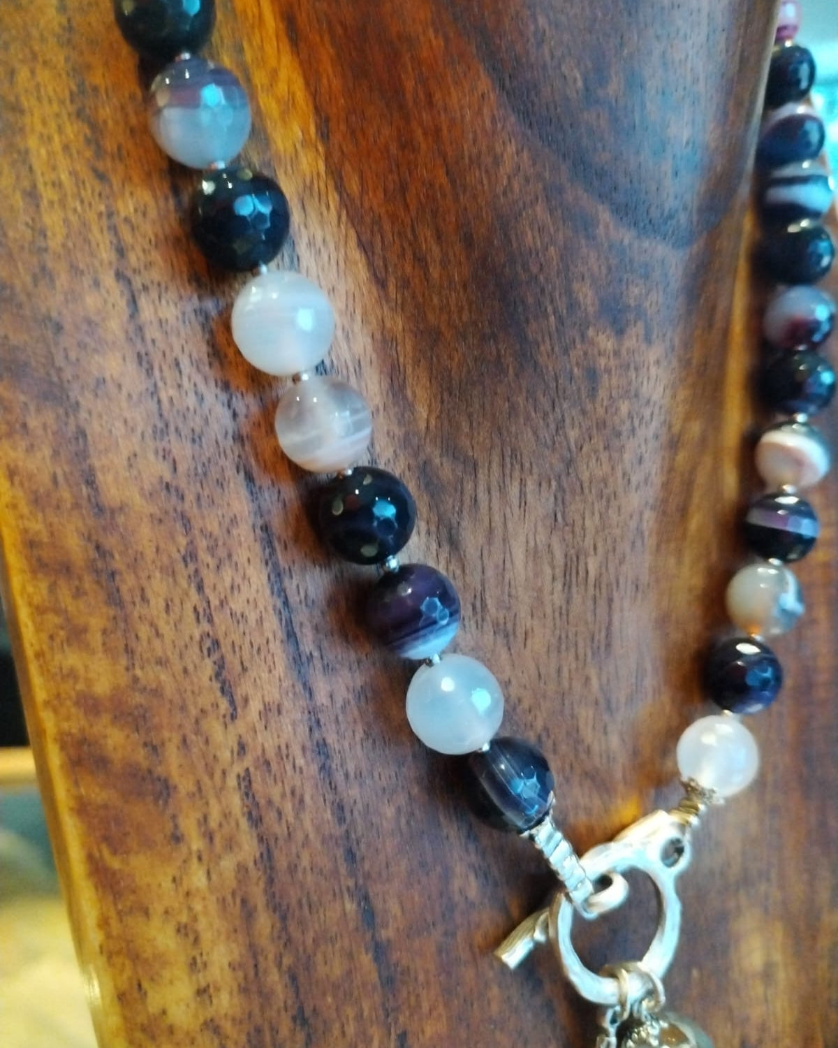 Necklace with beads and a key-shaped clasp on a wooden surface