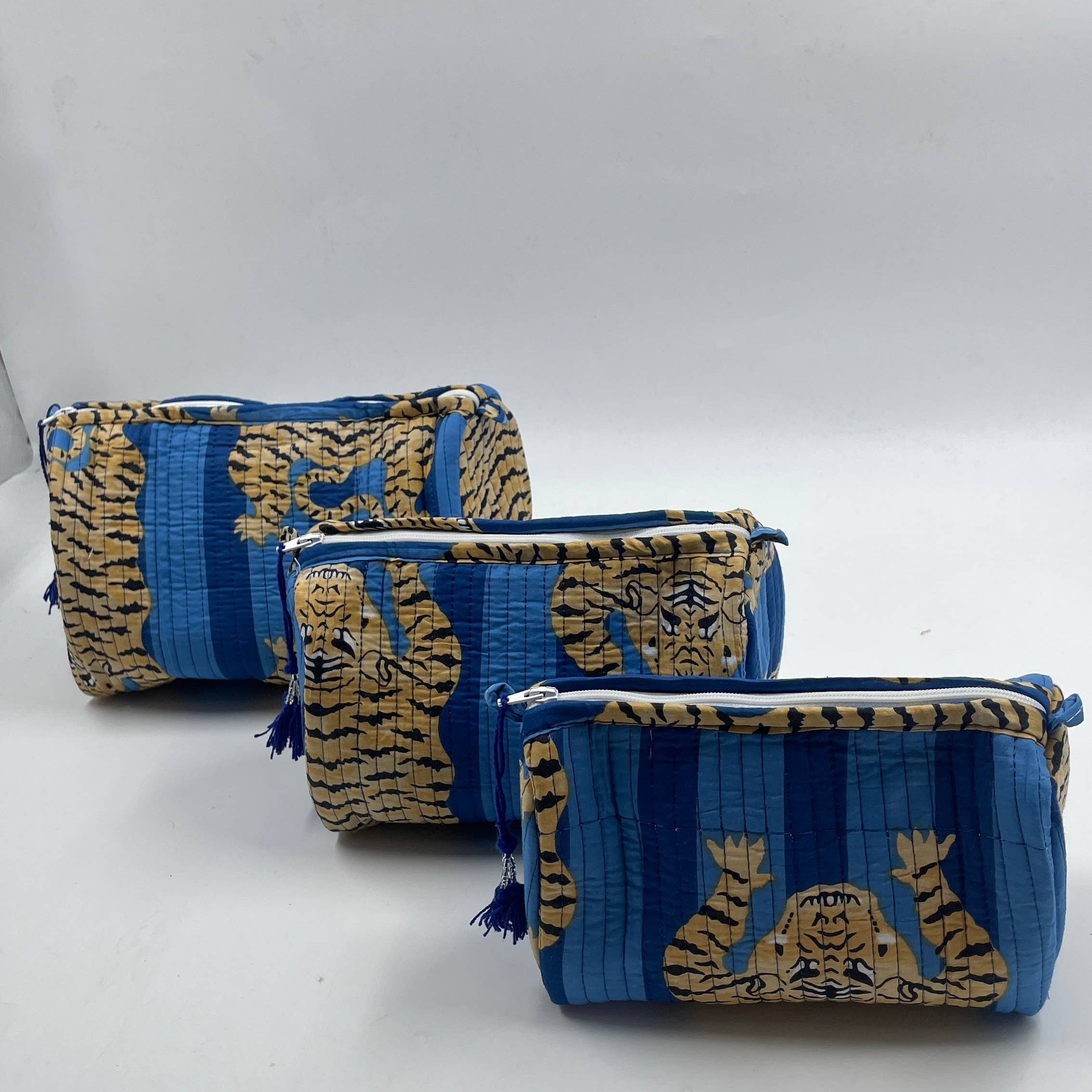 Two blue and gold patterned pouches on a white background