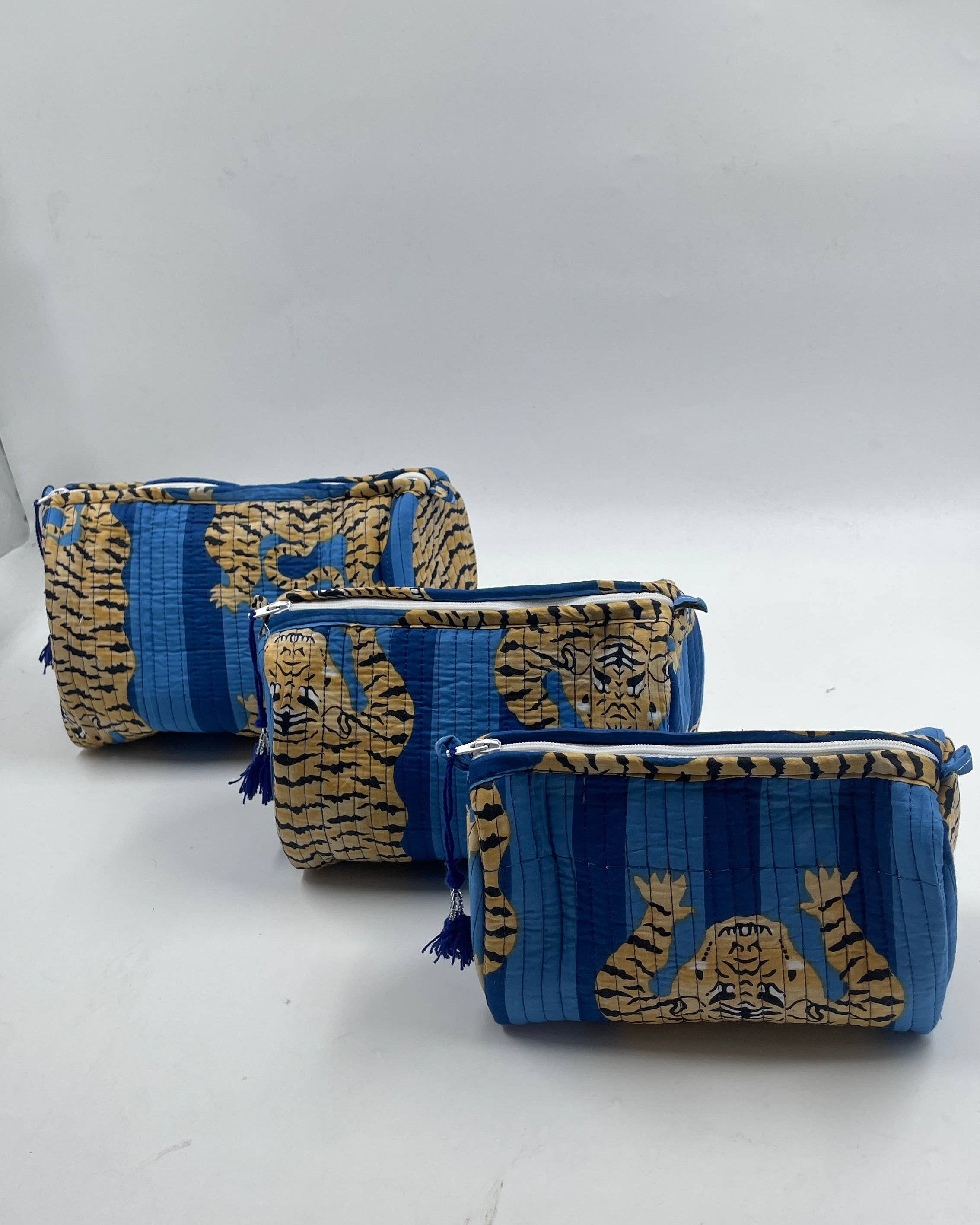 Two blue and gold patterned pouches on a white background