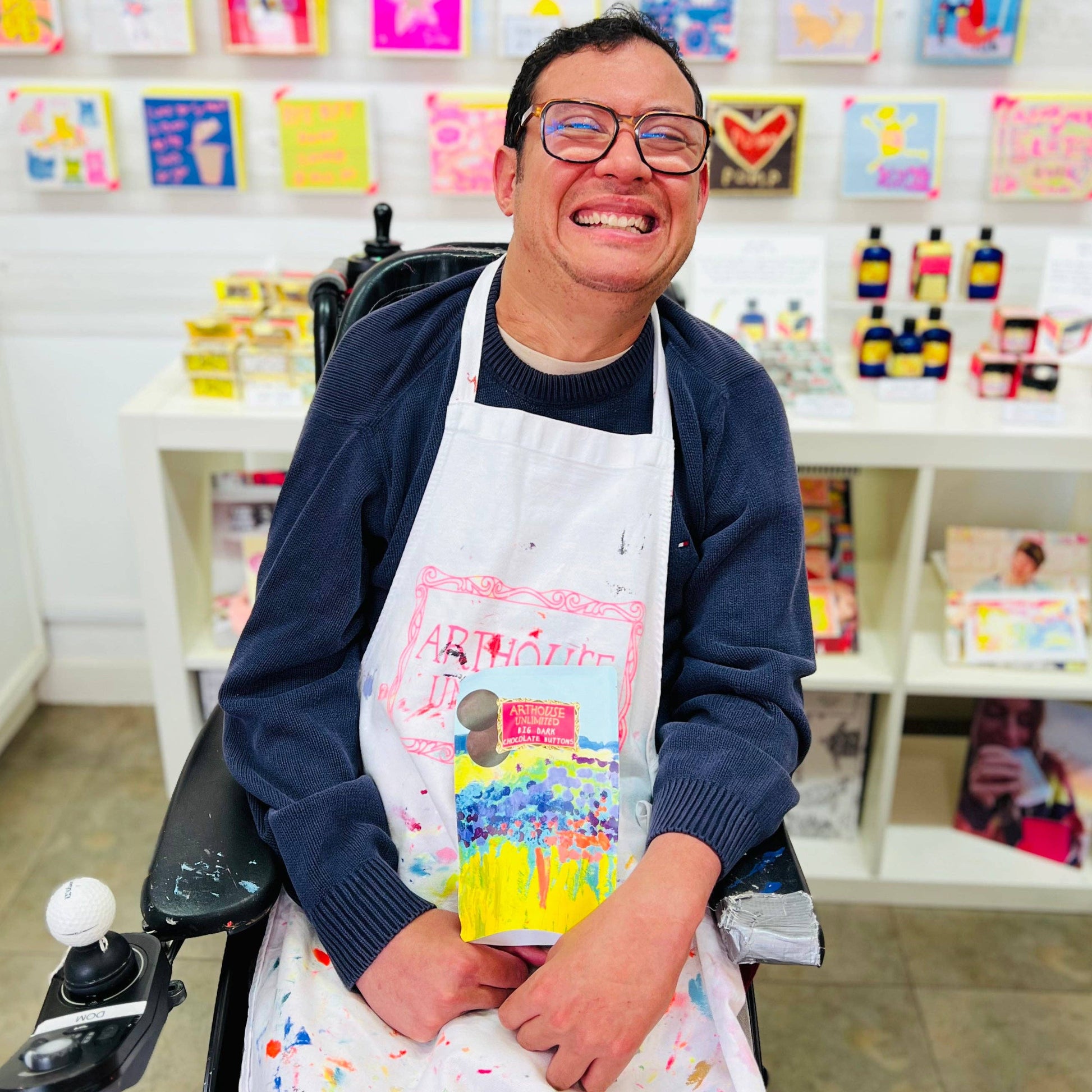 Person wearing a colorful apron in an art studio setting