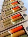 Set of colorful candles in cardboard packaging with visible brand name.