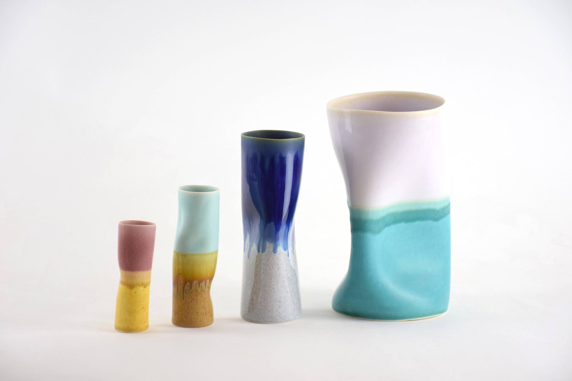 Set of four ceramic vases with gradient colors on a white background