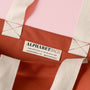 Close-up of a bag with 'Alphabet Bags' label on a pink background