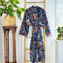 Floral patterned robe hanging on a wooden ladder with plants in the background