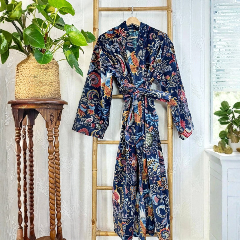 Floral patterned robe hanging on a wooden ladder with plants in the background