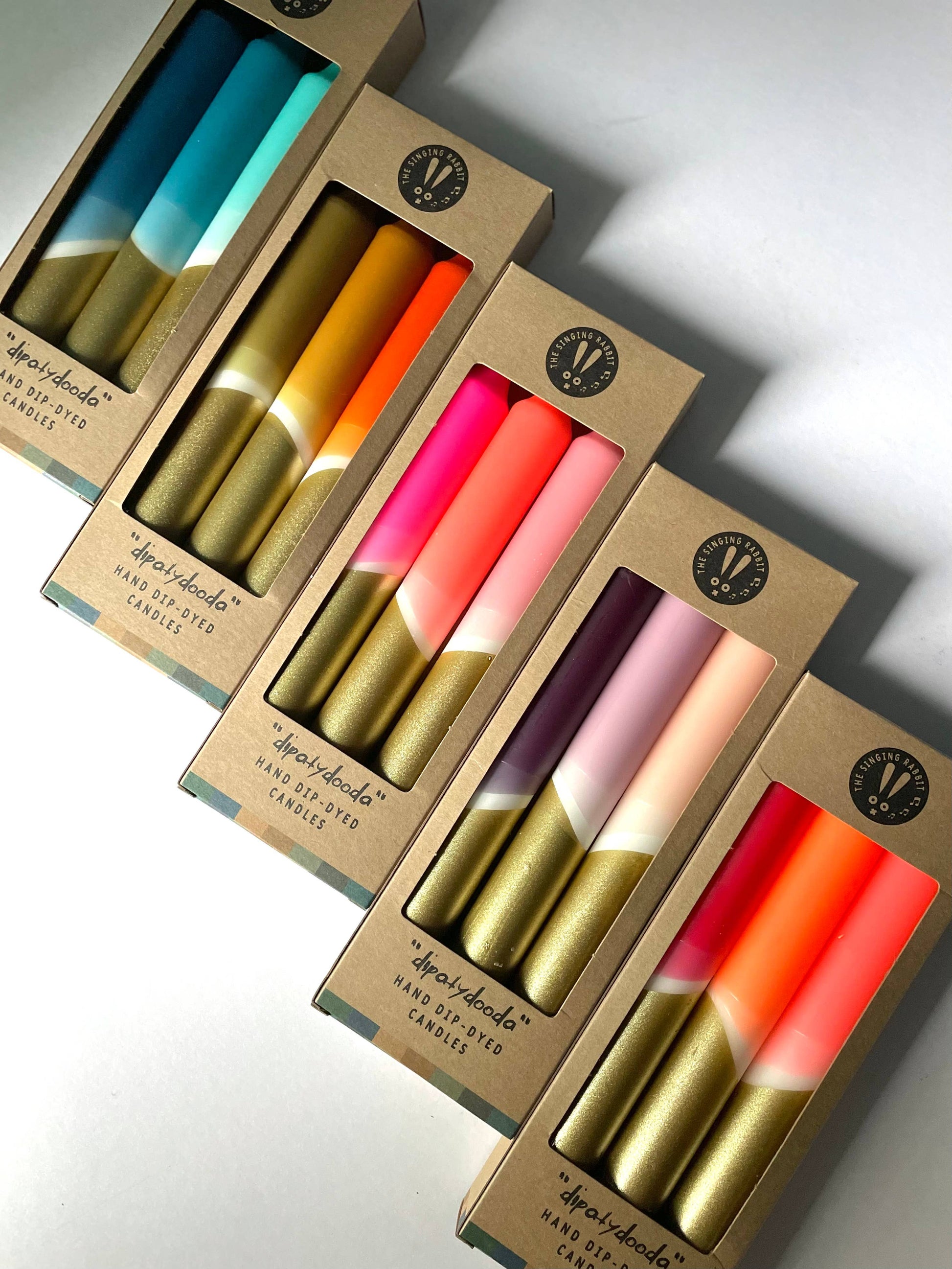 Set of colorful candles in cardboard boxes on a light background