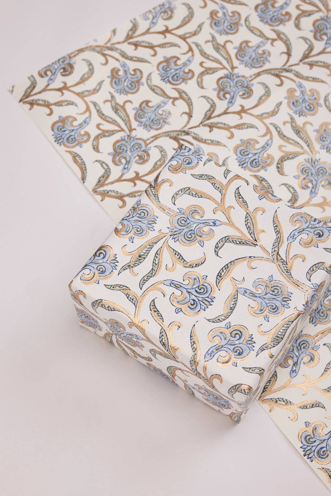 Roll of floral patterned fabric on a light background