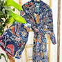 Colorful patterned robe on a wooden chair with plants in the background