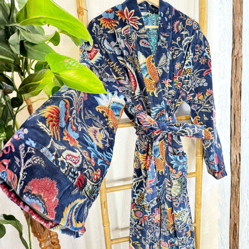 Colorful patterned robe on a wooden chair with plants in the background
