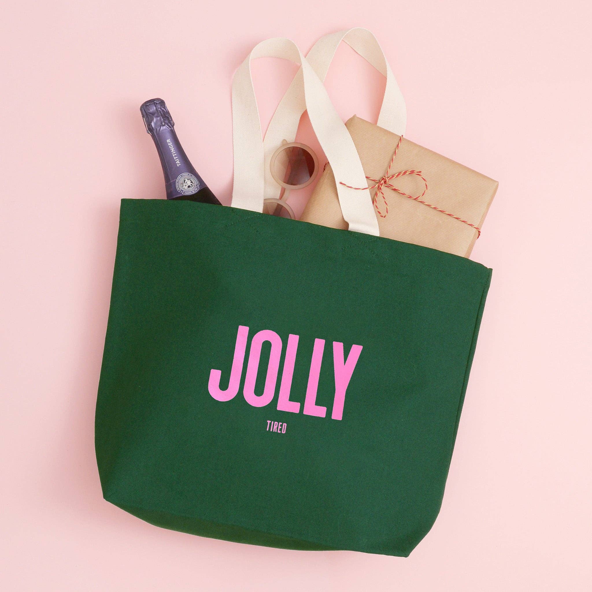 Green tote bag with 'Jolly' text on a pink background