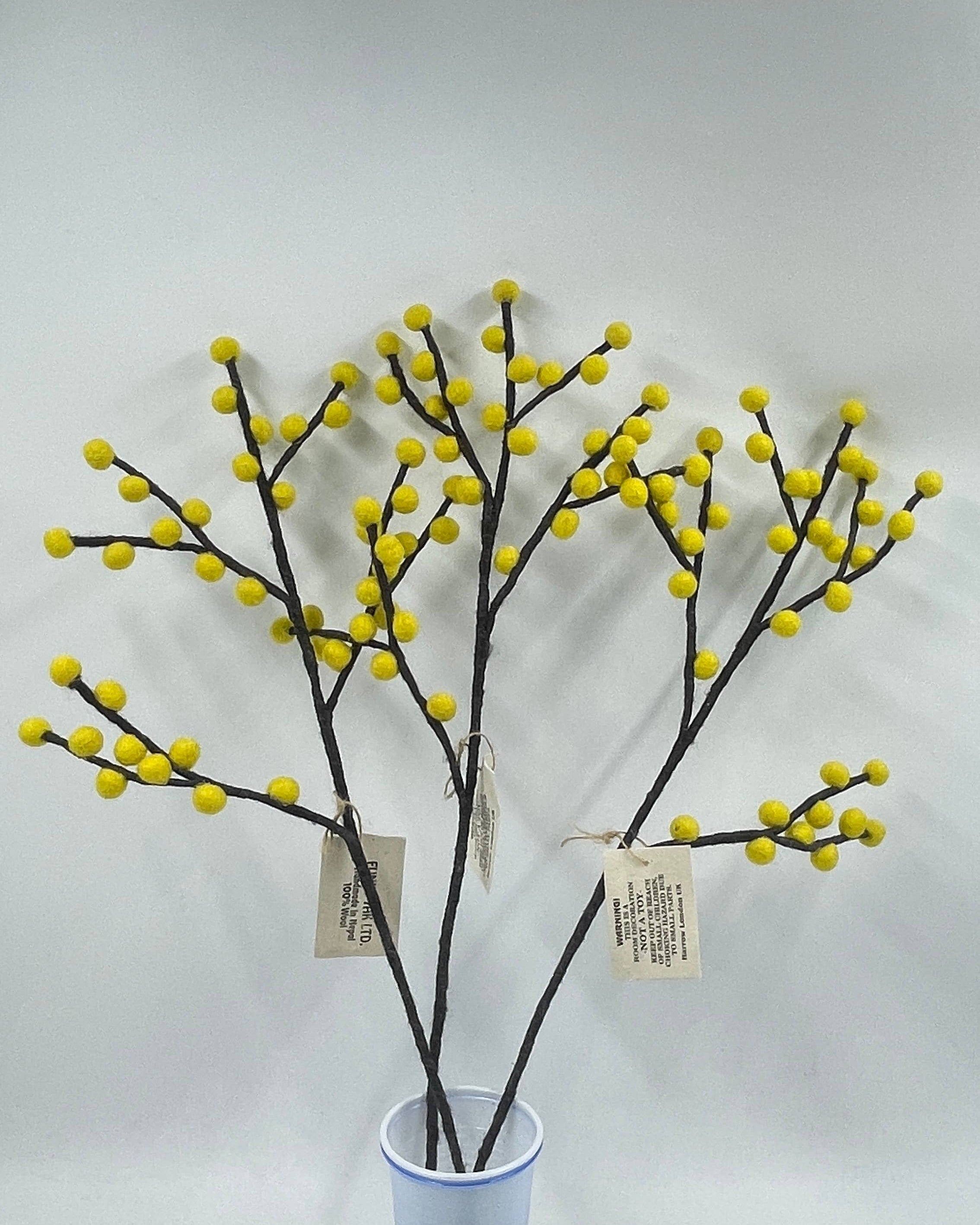 Decorative plant with yellow spherical ends in a blue vase on a white background