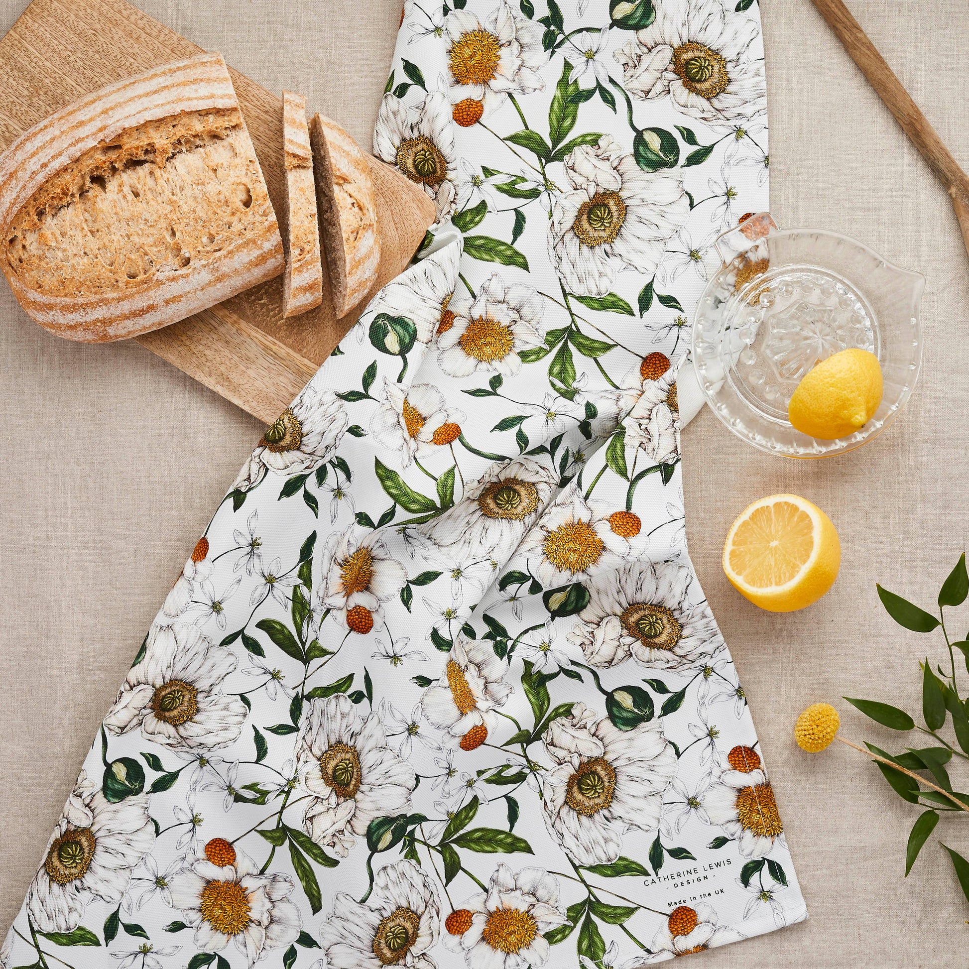Floral-patterned towel on a table with bread and lemons