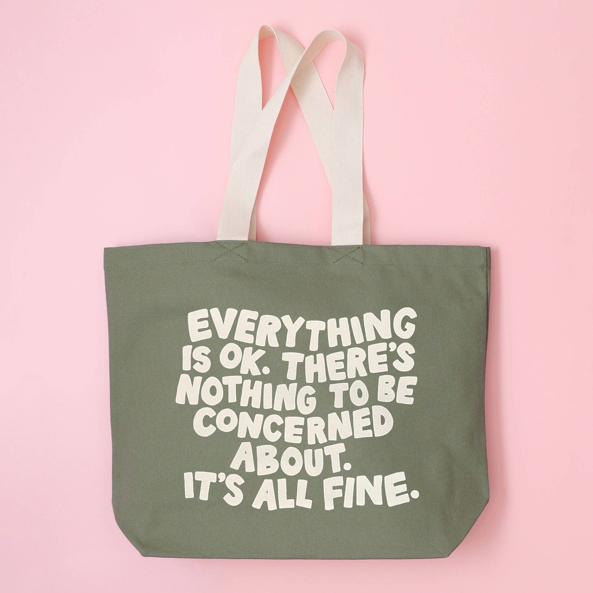 Green tote bag with motivational quote on a pink background