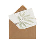 Brown envelope with a white card featuring green leaf design on a white background