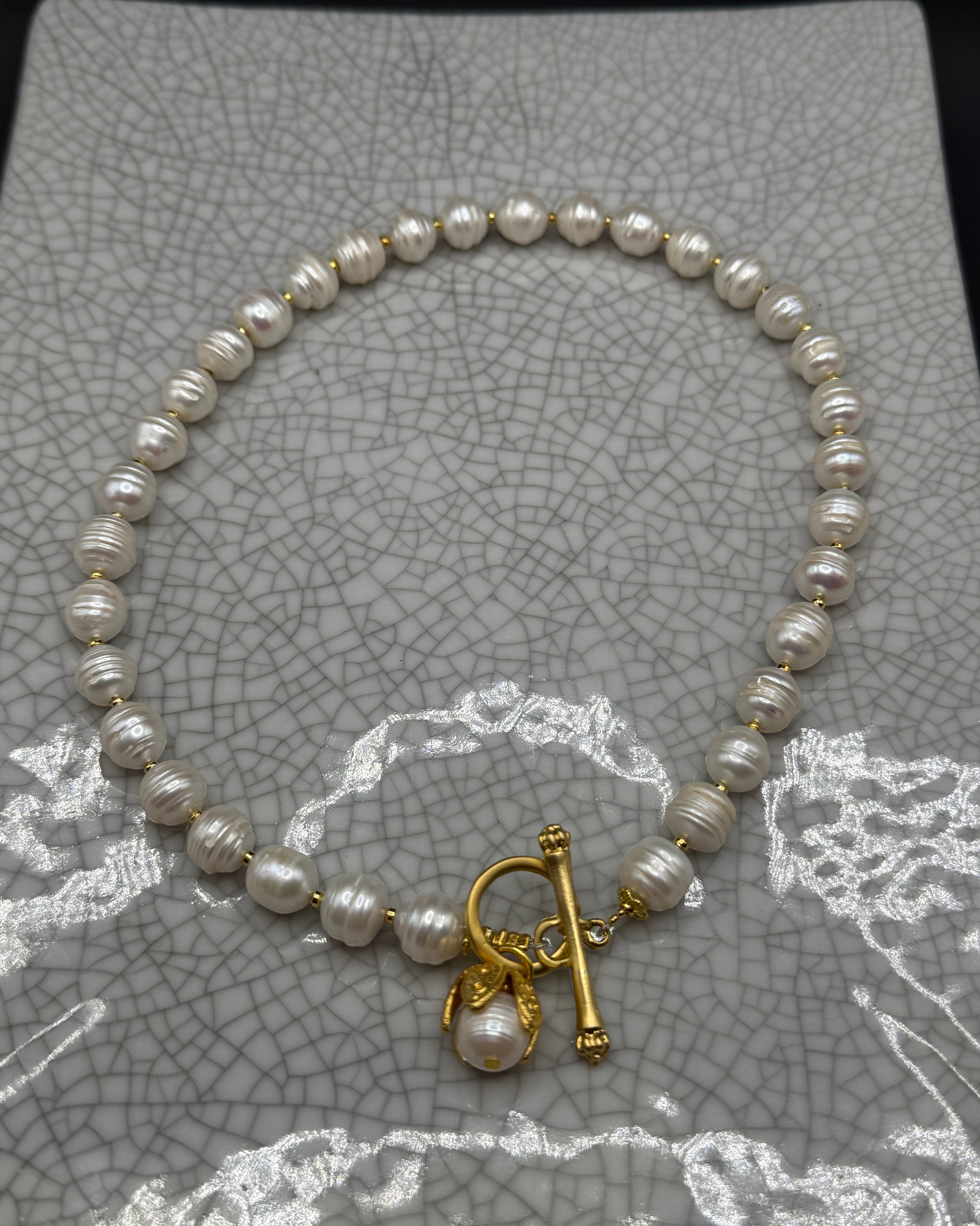 Freshwater pearl necklace with gold spacers, front T-bar clasp and pearl drop in a gold petal bud, handmade in Bristol
