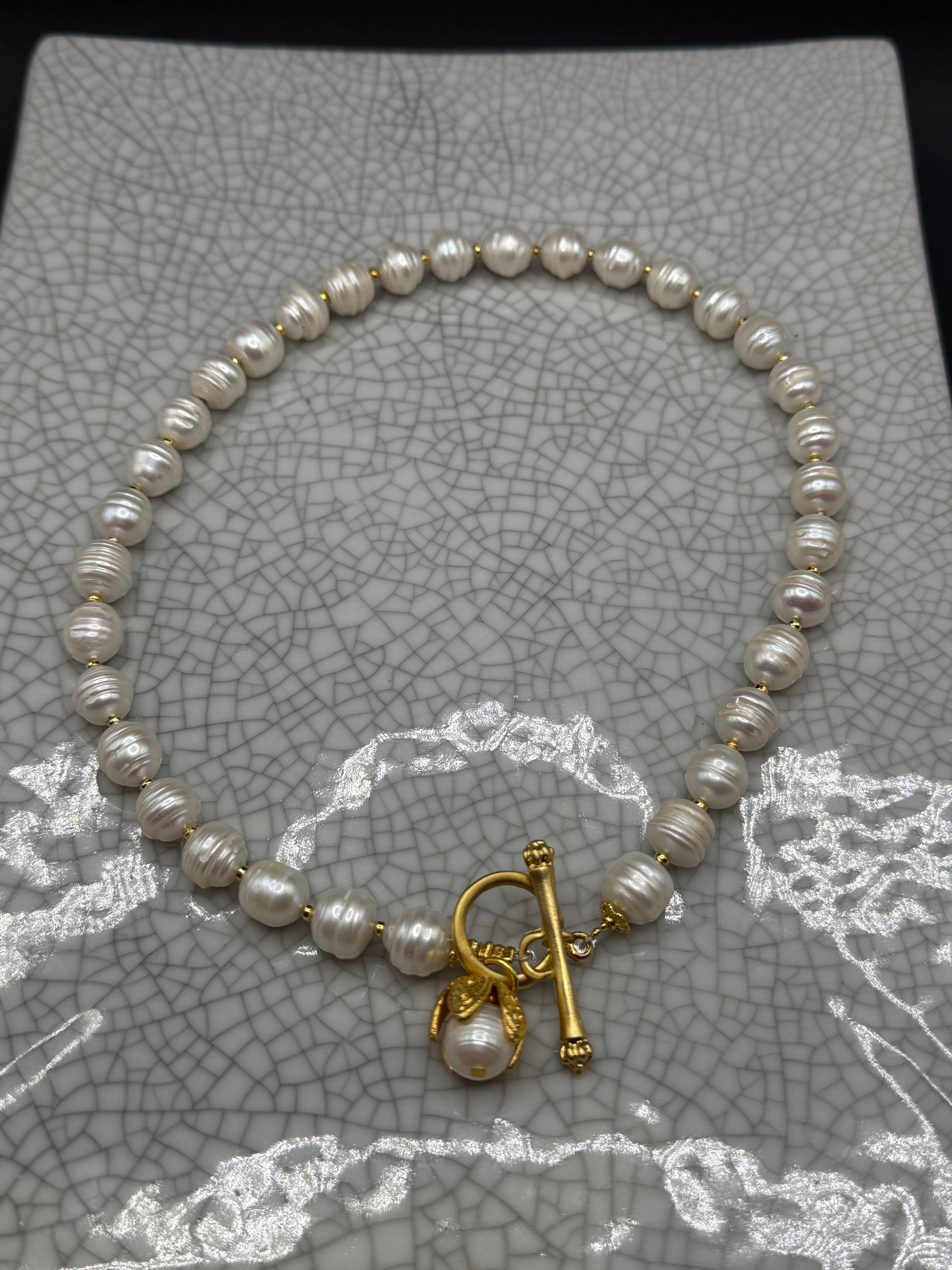 Freshwater pearl necklace with gold spacers, front T-bar clasp and pearl drop in a gold petal bud, handmade in Bristol