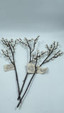 Decorative branches with small white berries on a light gray background