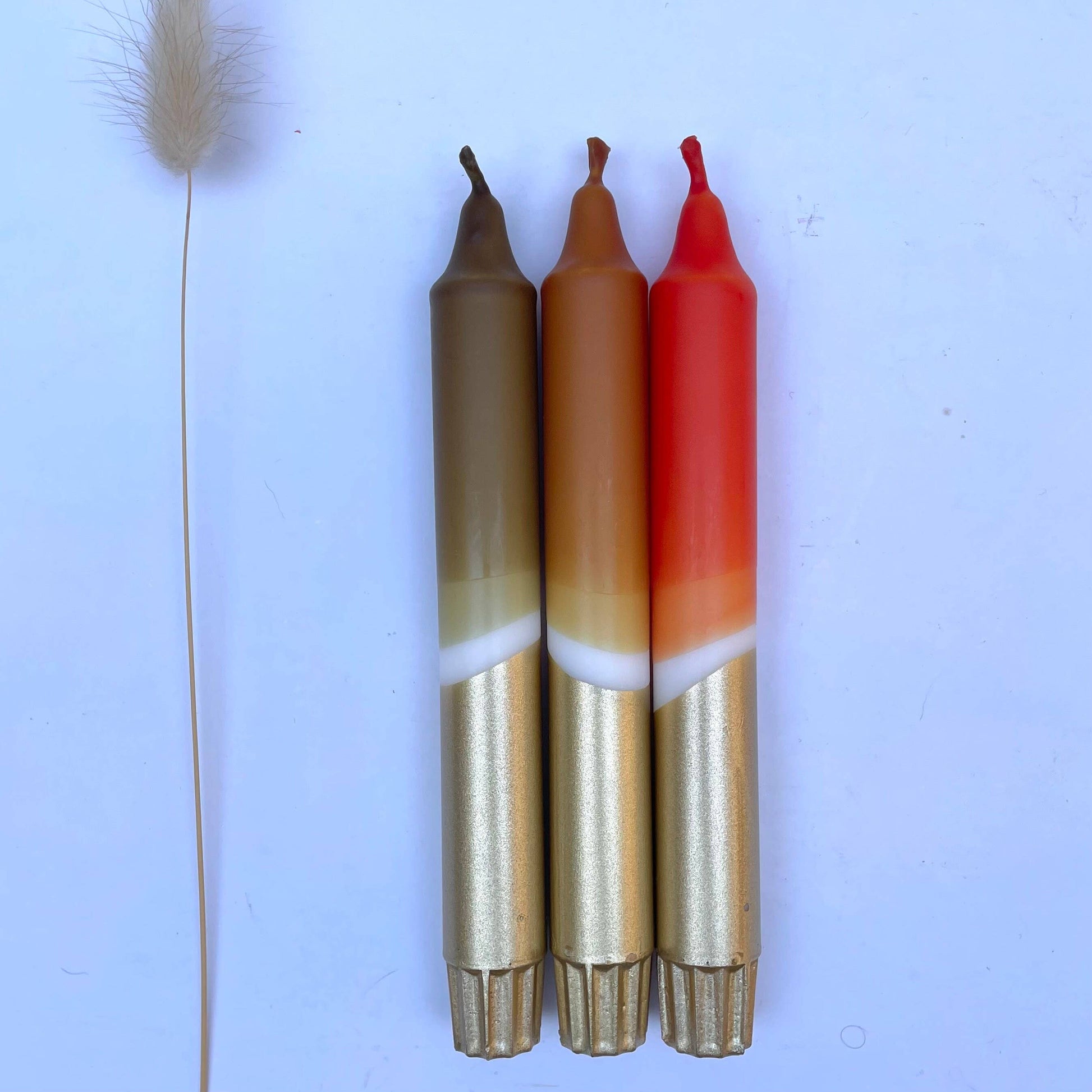 Three fishing float candles with different colors on a light blue background