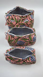 Set of three floral-patterned pouches on a white background