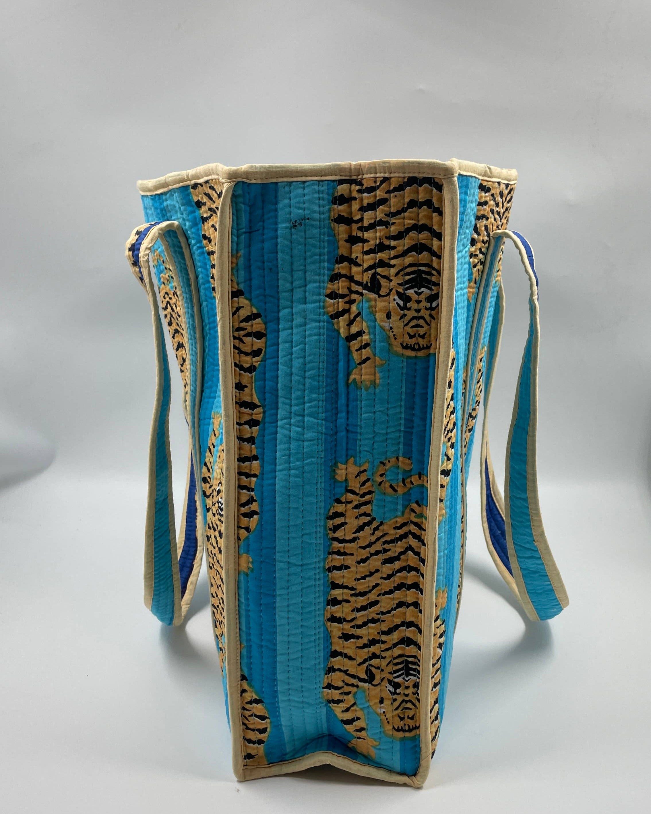 Blue bag with gold tiger designs on a gray background