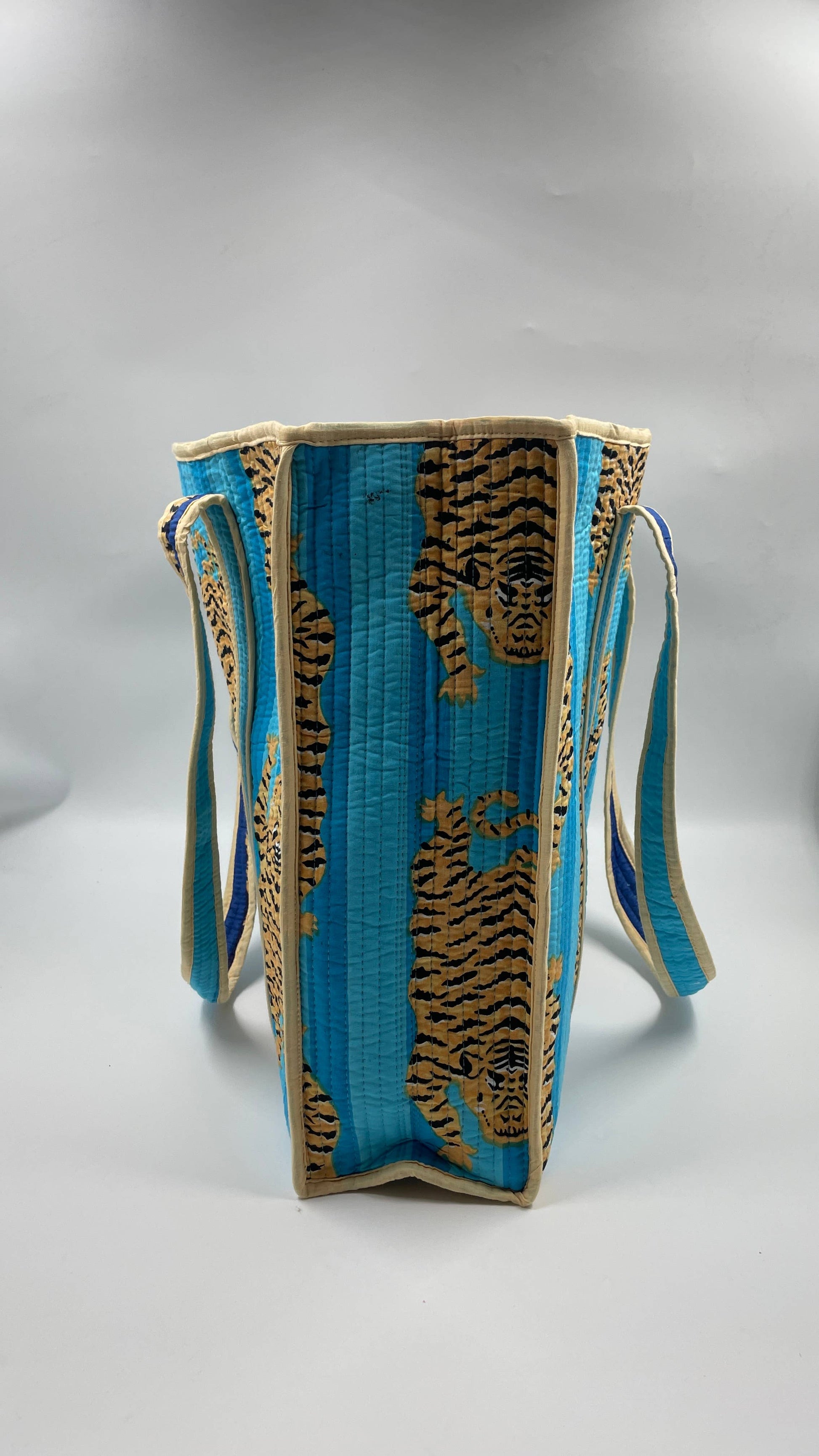 Blue bag with gold tiger designs on a gray background