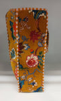 Decorative folded fabric with floral and bird patterns on a plain background
